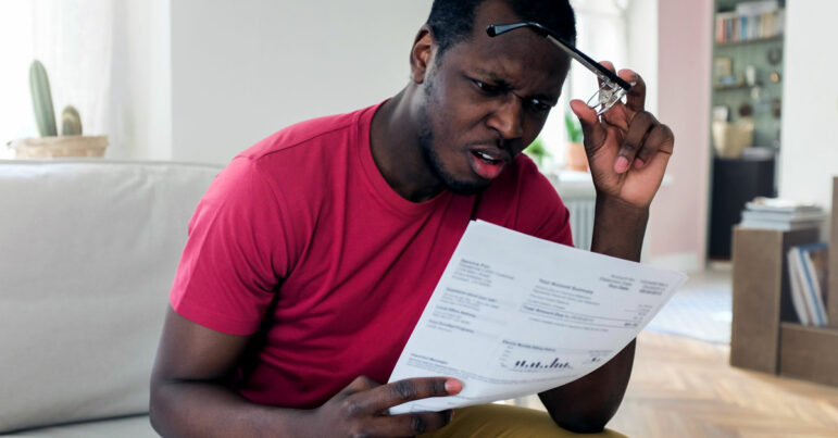 Man looking at hospital bill with shocked face