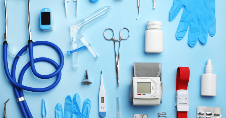 Medical devices like gloves, scissors, and a stethoscope laid out on a blue background.