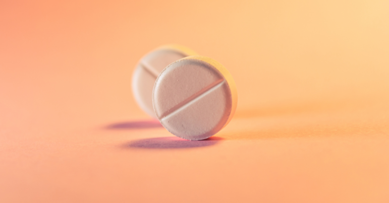 small circular pills on an orange background